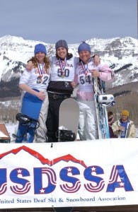 Three female snowboarders taking photos together